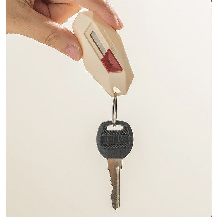 Cutter pentru Cutii si Colete, Varf Rotunjit cu Lama Zimtata, Rebound Automat si Magnet, ABS si Otel Inoxidabil, Tip Breloc, 6.5x3.5 cm, Crem