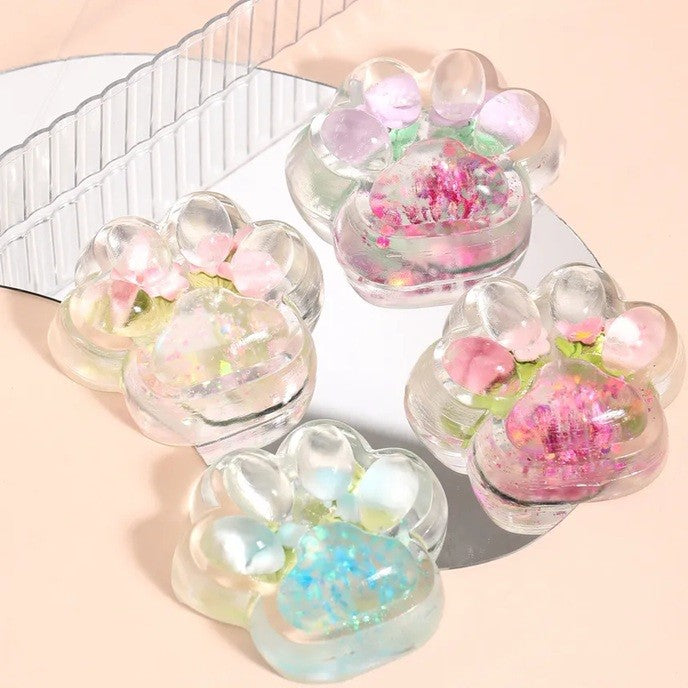 Jucarie Antistres Squishy, Labuta de Pisica Pufoasa cu Revenire Lenta si Insertii Flori, Material TPR Moale, 7 x 6.5 cm, Transparent Multicolor