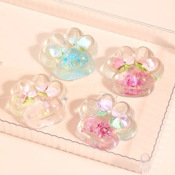 Jucarie Antistres Squishy, Labuta de Pisica Pufoasa cu Revenire Lenta si Insertii Flori, Material TPR Moale, 7 x 6.5 cm, Transparent Multicolor