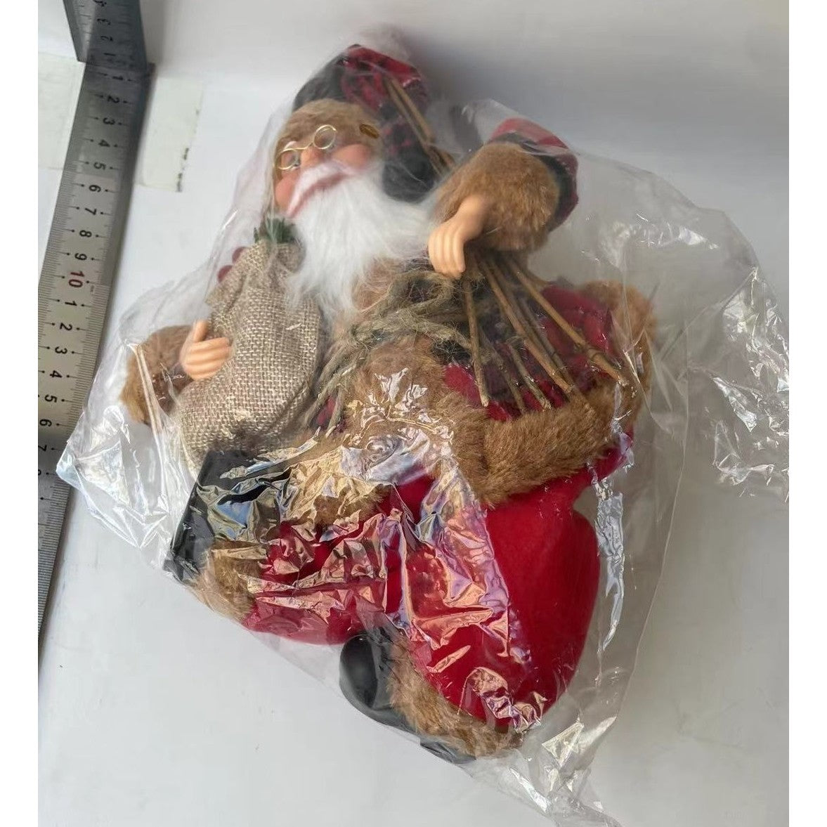 Figurina Decorativa Mos Craciun Asezat, Decoratiune Craciun cu Surcele, Interior si Exterior, Plastic si Textil, 35 x 18 x 20 cm, Rosu si Maro
