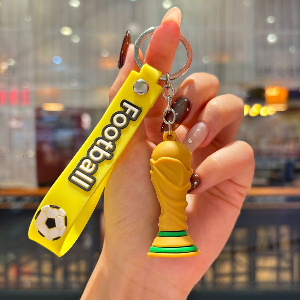 Breloc Chei Fotbal, Model Trofeu Mascota Cupa Mondiala, Accesoriu pentru Rucsac si Ghiozdan, Cauciuc Moale Flexibil, 6.2 x 3.4 cm, Galben